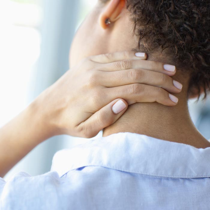 woman touching back of neck