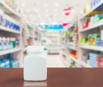 Pill bottle on table top on blurred pharmacy Pharmacy in shopping mall Pharmacy in shopping center Shoping drug and pill at pharmacy in holiday